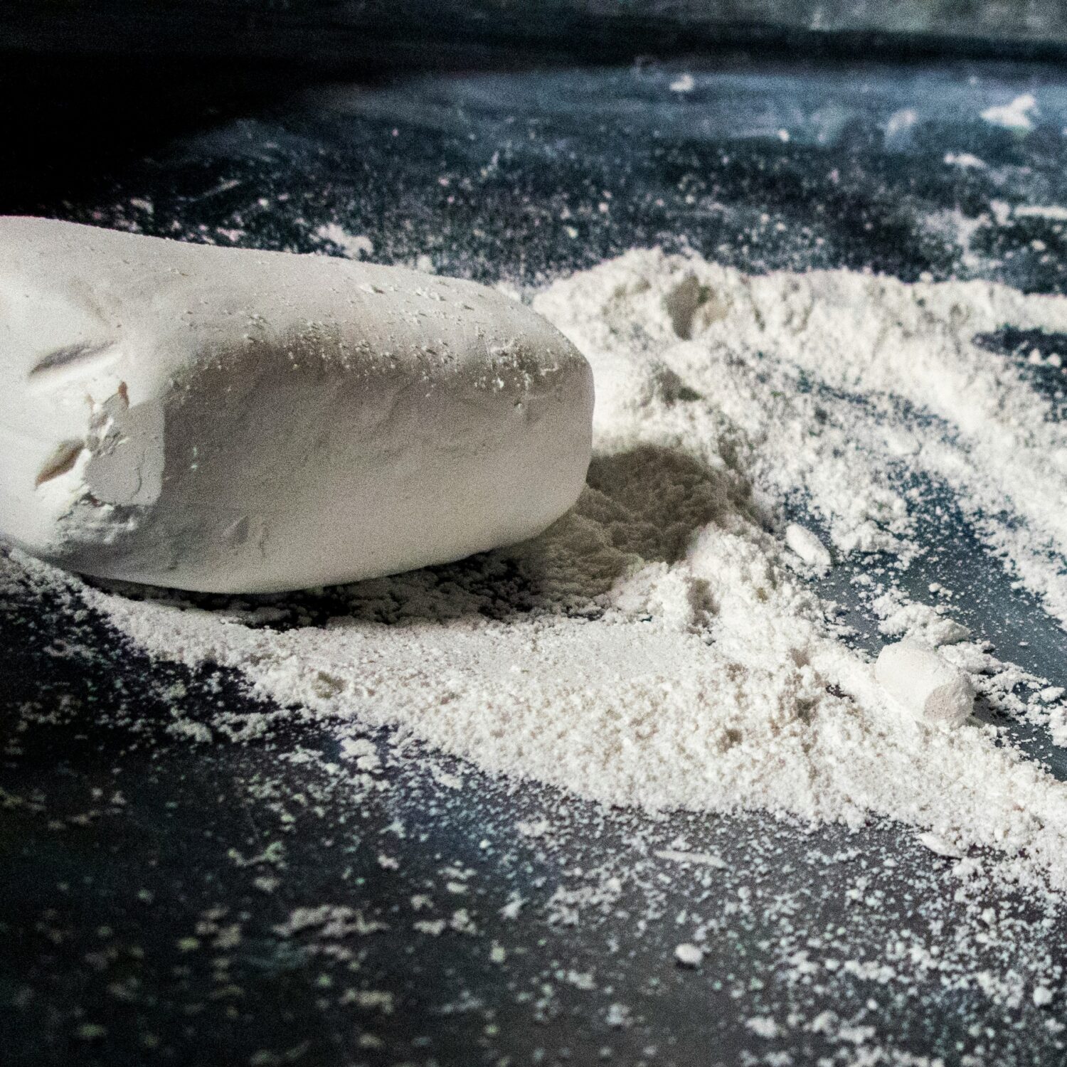 Close-up of gypsum powder and a gypsum block on a dark surface