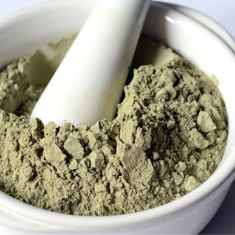Fine green cosmetic clay powder in a mortar with pestle