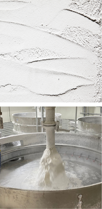 Textured lime plaster surface above an industrial lime milk mixing tank