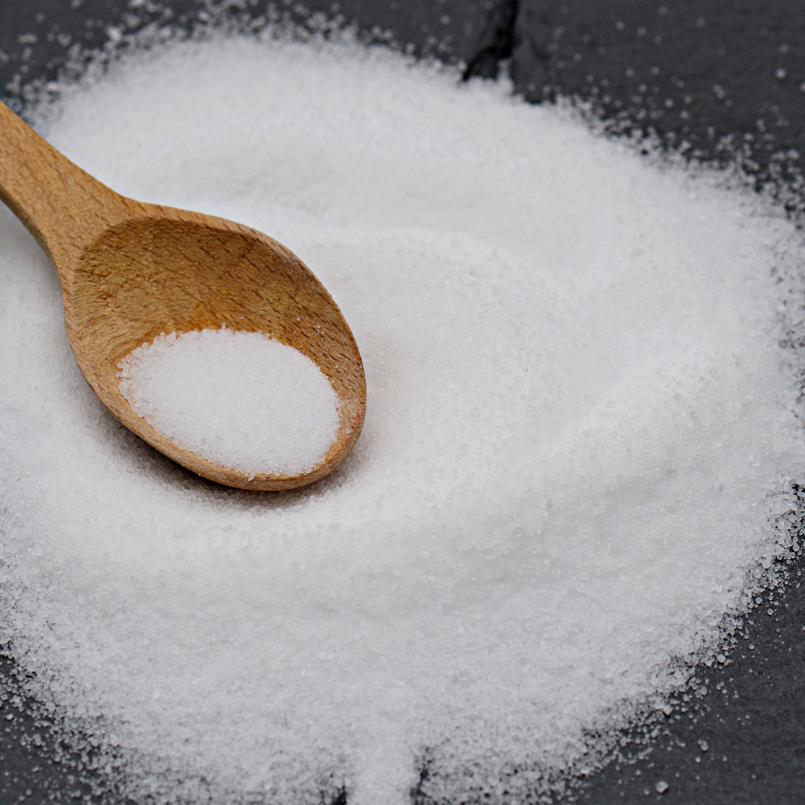crystalline salt with wooden spoon showing typical food and industrial grade requiring foreign body removal and agglomerate separation