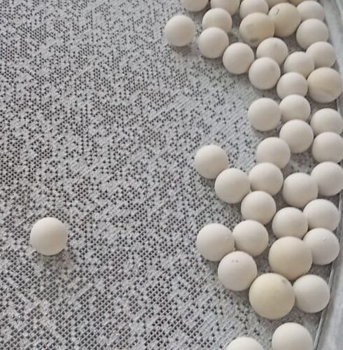 Under-mesh cleaning balls showing uneven wear on vibrating sieve mesh